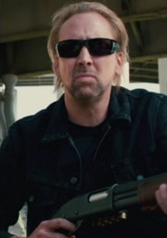 Magnifique photo d'un Nicolas Cage blond et patibulaire équipée de lunettes de soleil et d'un fusil à pompe.